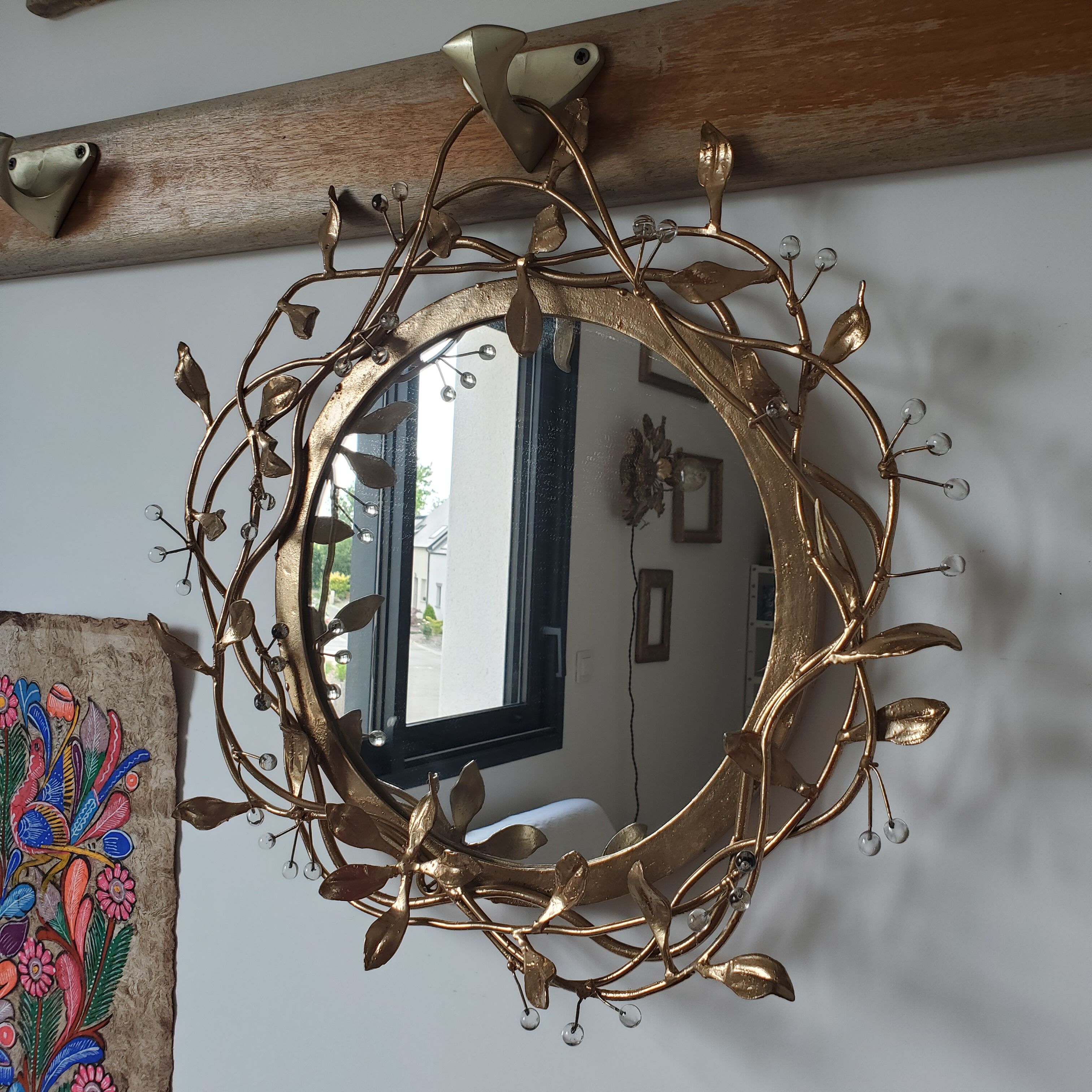 Round mirror in gilded wrought iron and leaves