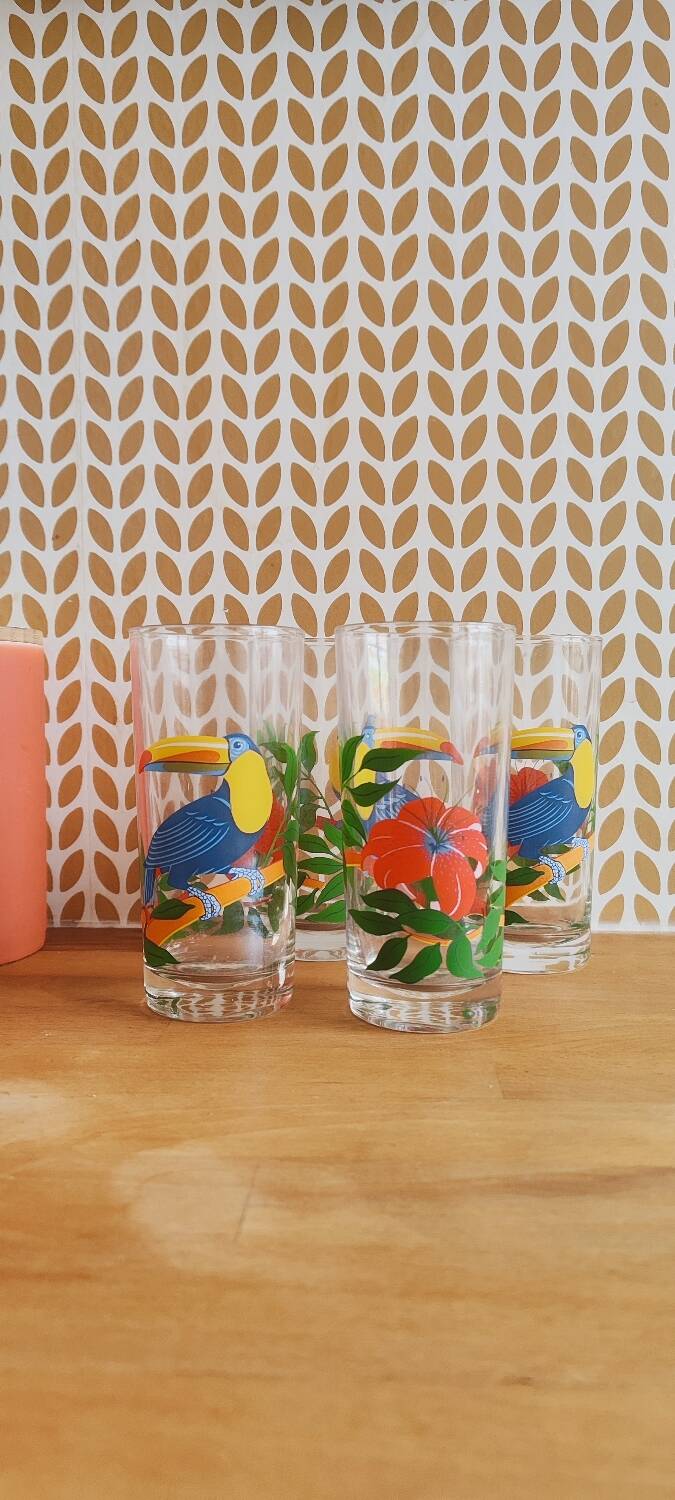 Vintage lemonade glasses with tropical parrot and flower patterns.