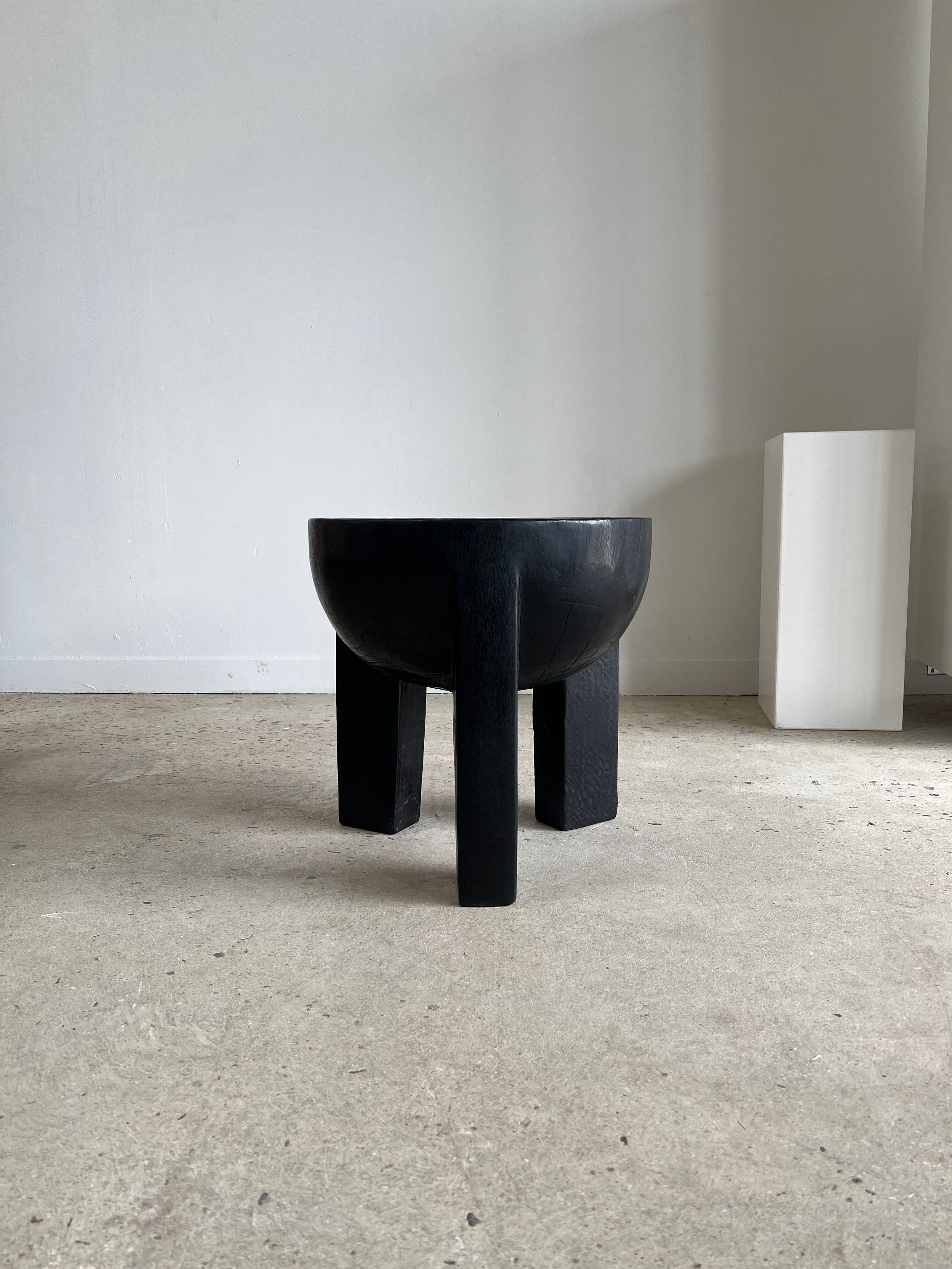 Black mango wood tripod side table with a semi-spherical top, height: 45 cm, diameter: 44 cm.