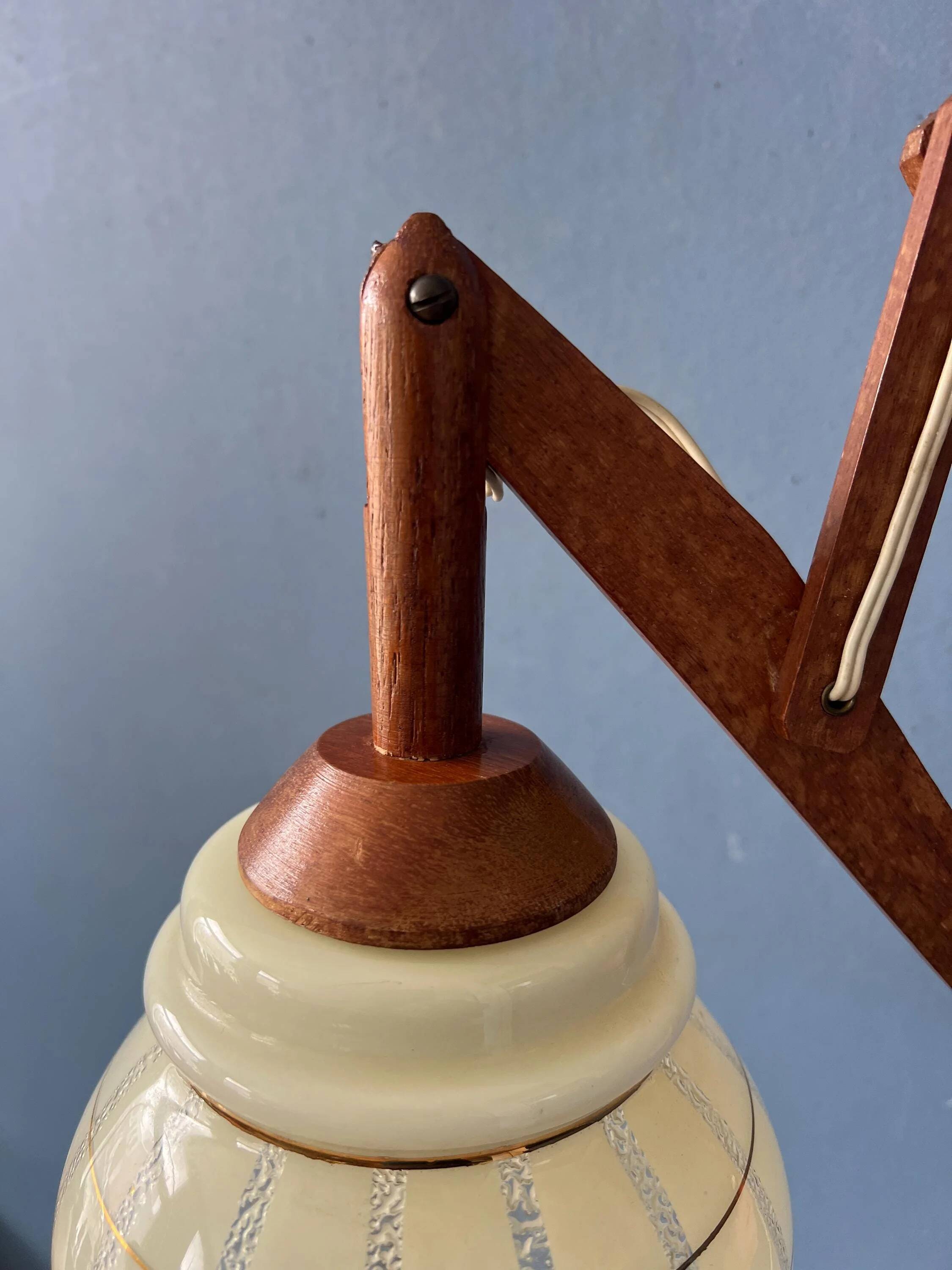 Vintage wall lamp with teak wood scissors and glass shade.