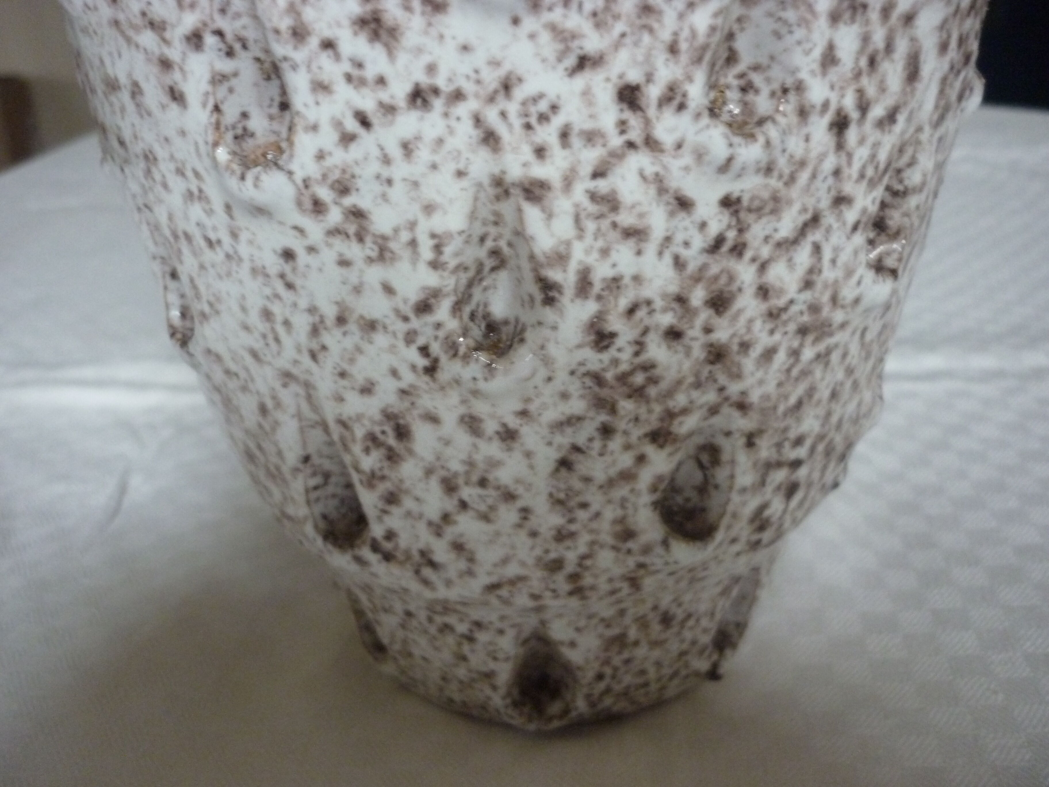 Spotted white ceramic vase with hollow form of tears