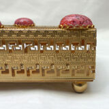 Empty pocket in gold metal and pink stones