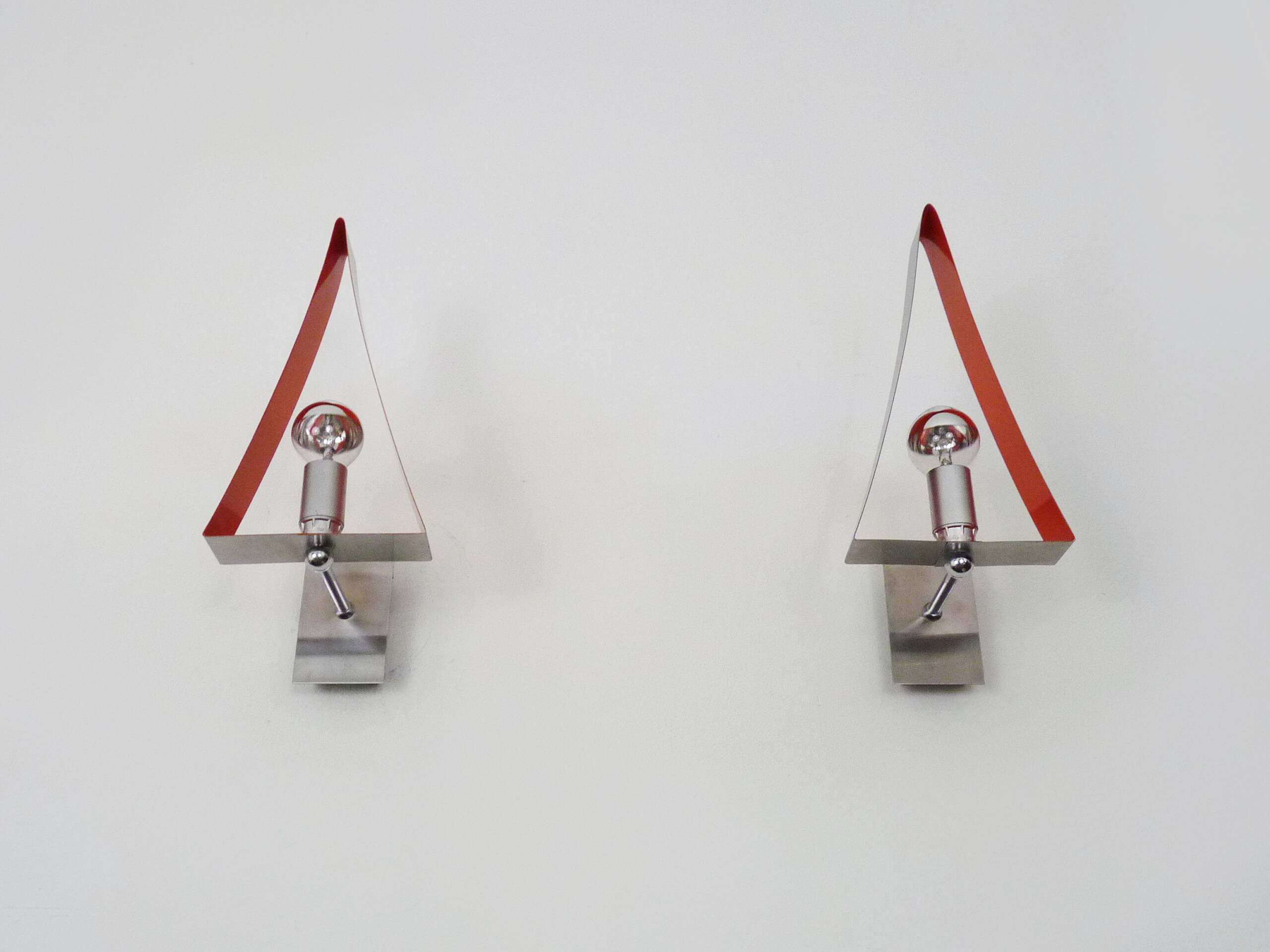 Pair of triangular wall sconces in chrome metal and orange. 1970s.
