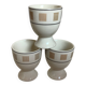 Three egg cups with geometric patterns in beige and brown.