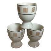 Three egg cups with geometric patterns in beige and brown.