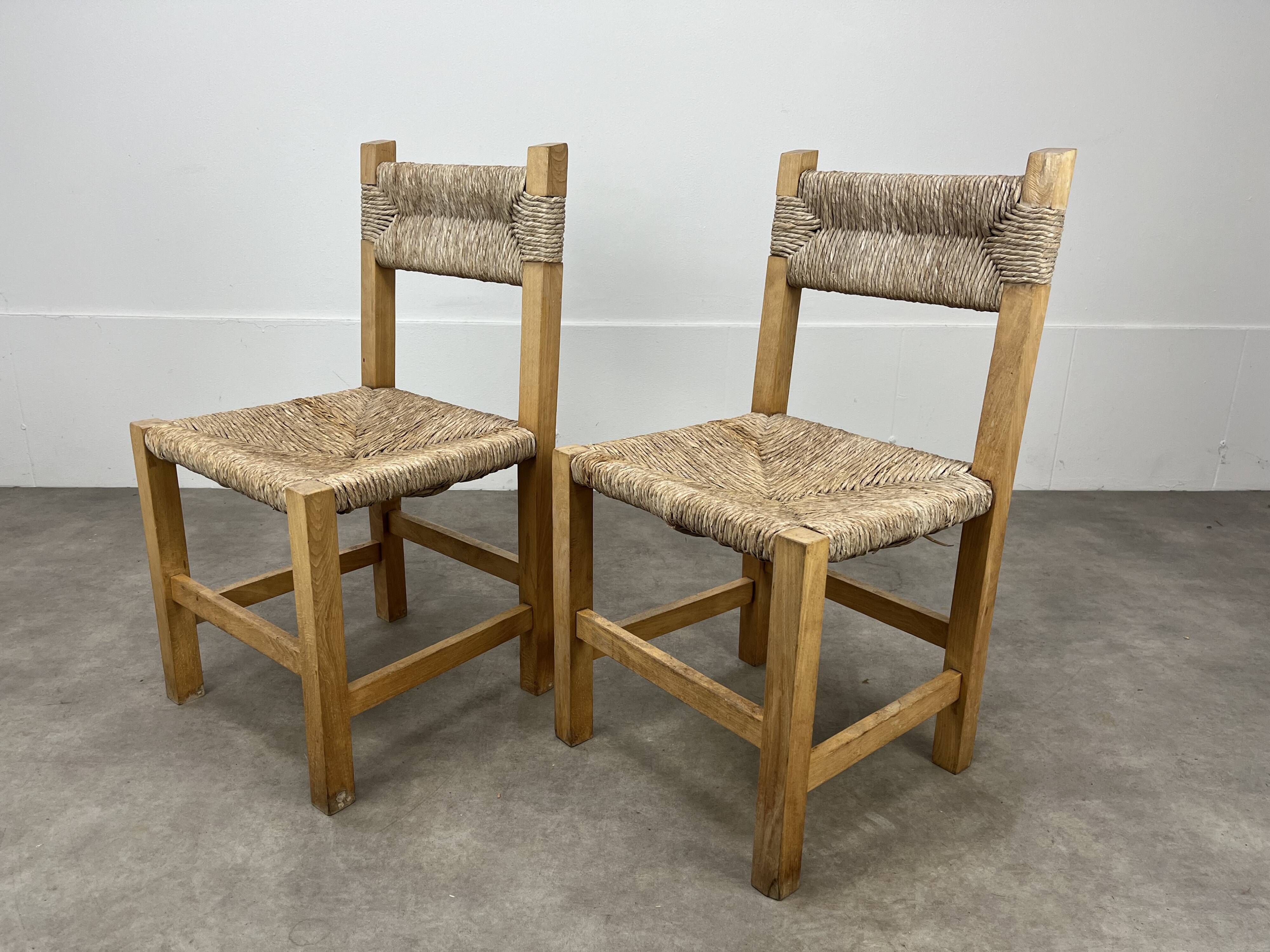 2 straw and wood chairs in brutalist style