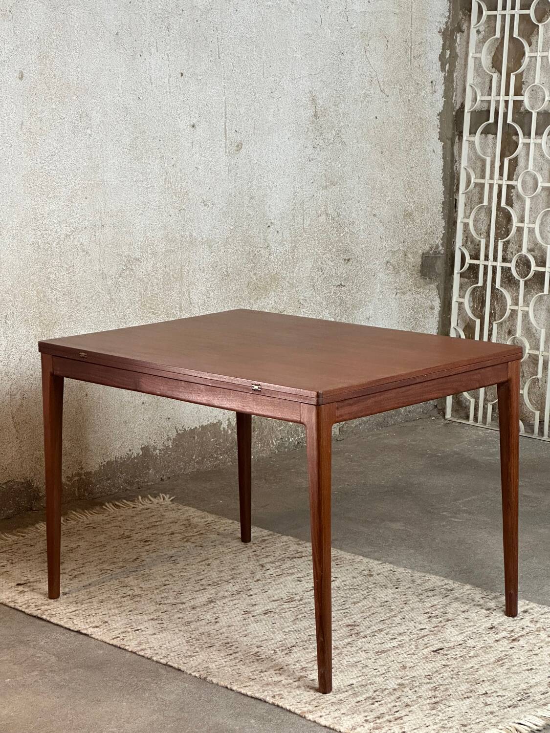 Extendable teak and teak veneer dining table