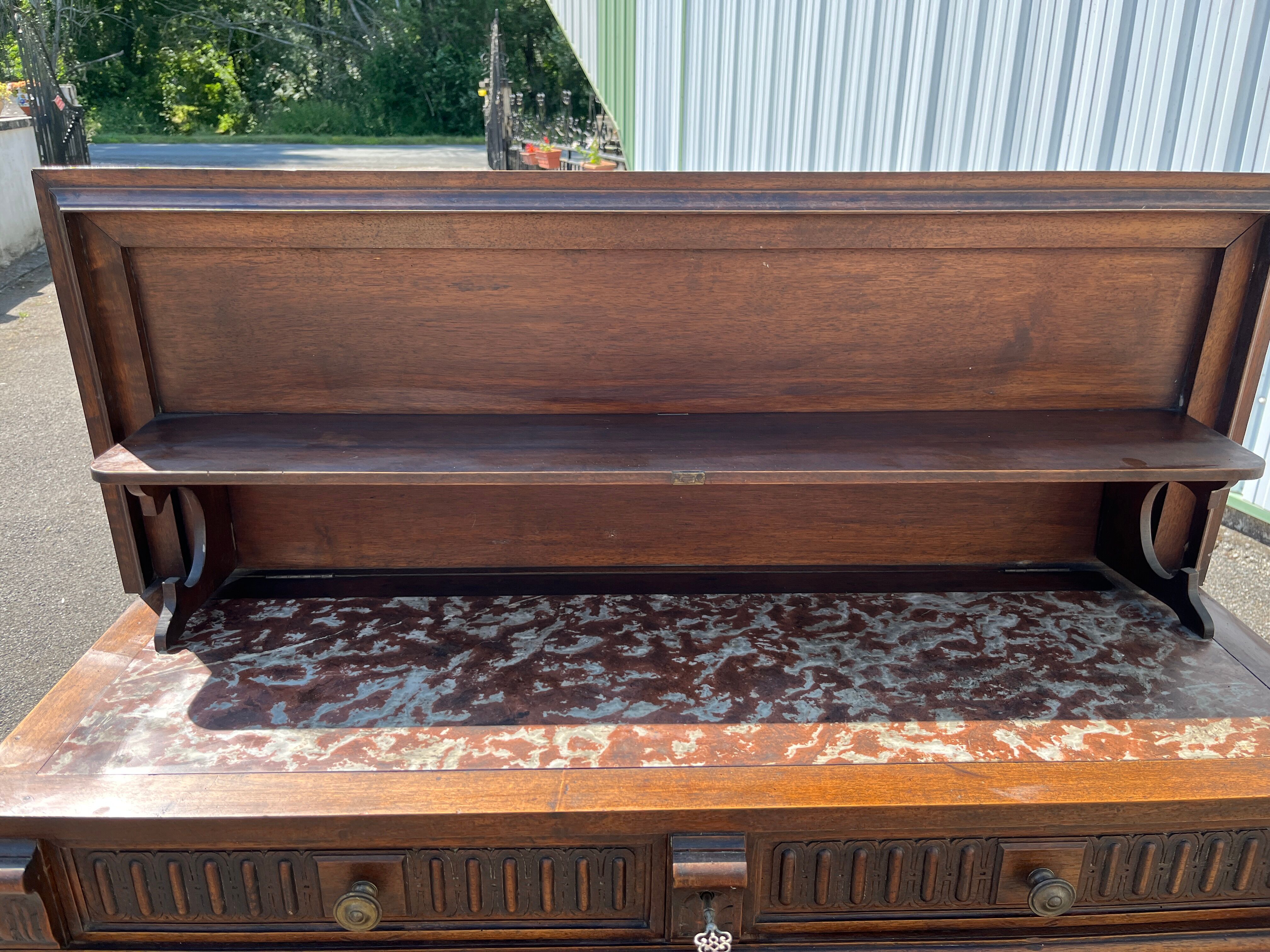 Carved wooden console table with three shelves and drop-leaf flap