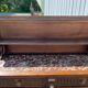 Carved wooden console table with three shelves and drop-leaf flap