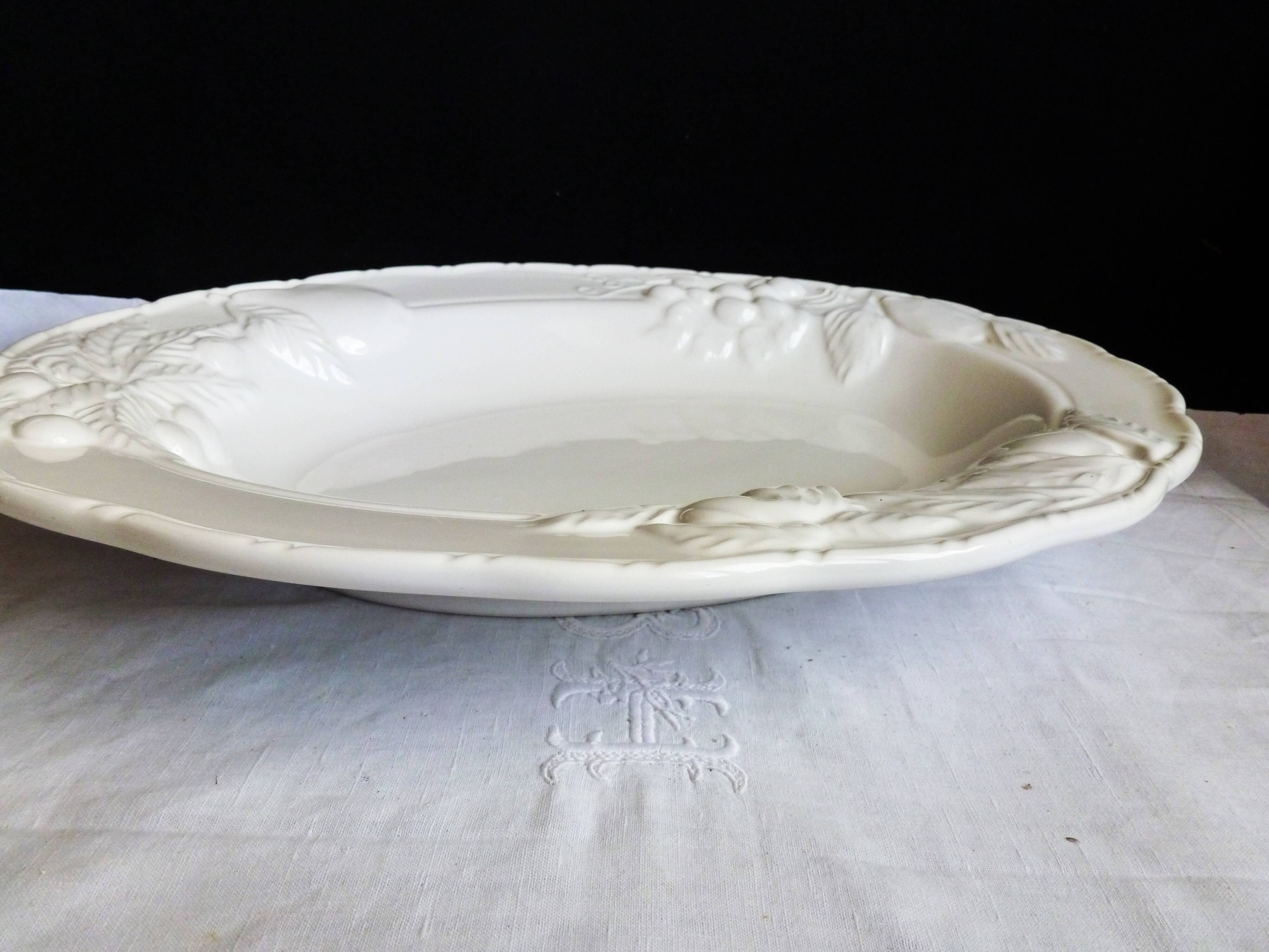 Oval white vegetable dish, an antique tableware piece in barbotine earthenware.
