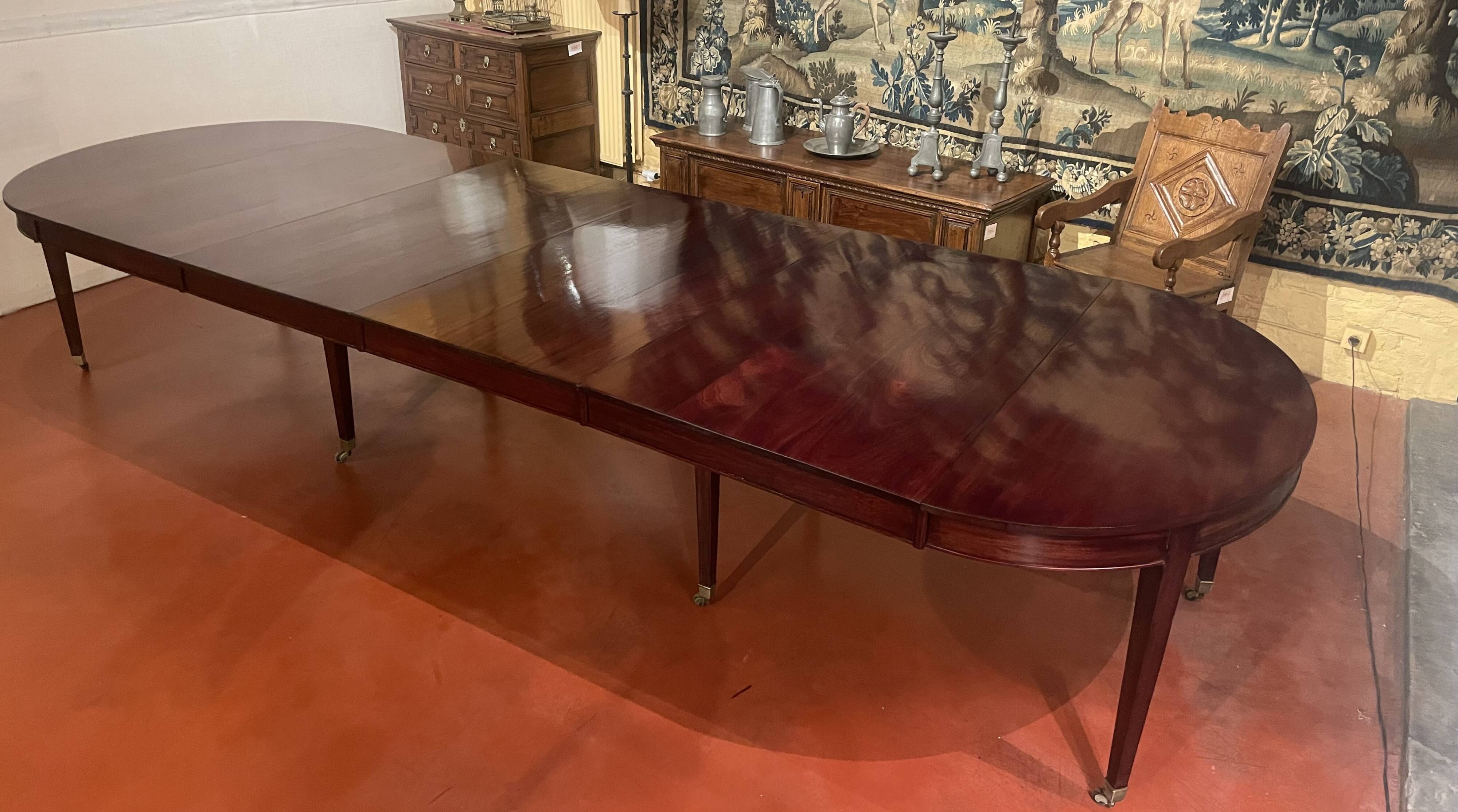 Directoire period extendable dining table in mahogany with a band.