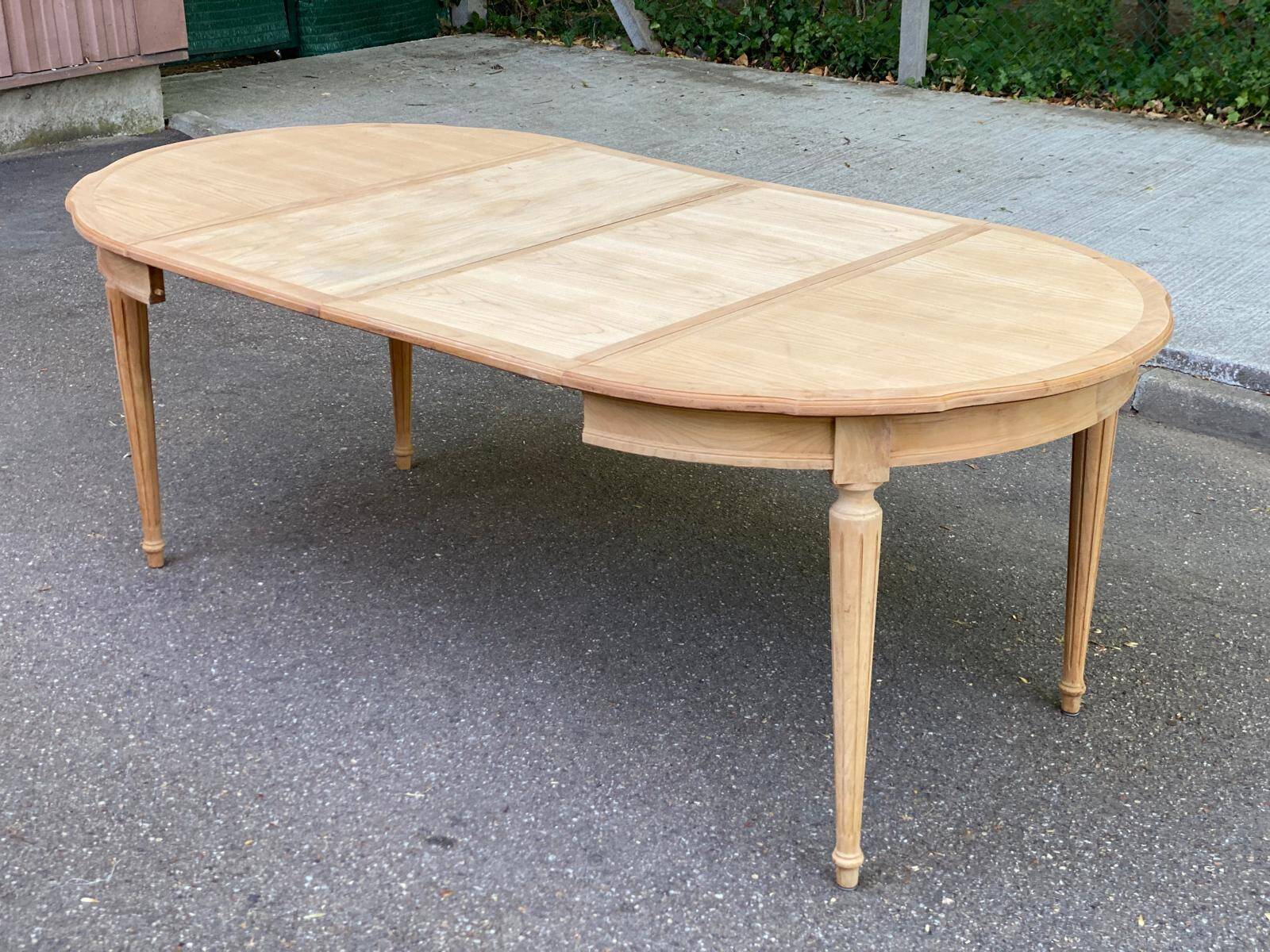 Extendable round table in renovated Louis XVI style, made of light wood, with 2 extensions.
