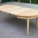 Extendable round table in renovated Louis XVI style, made of light wood, with 2 extensions.