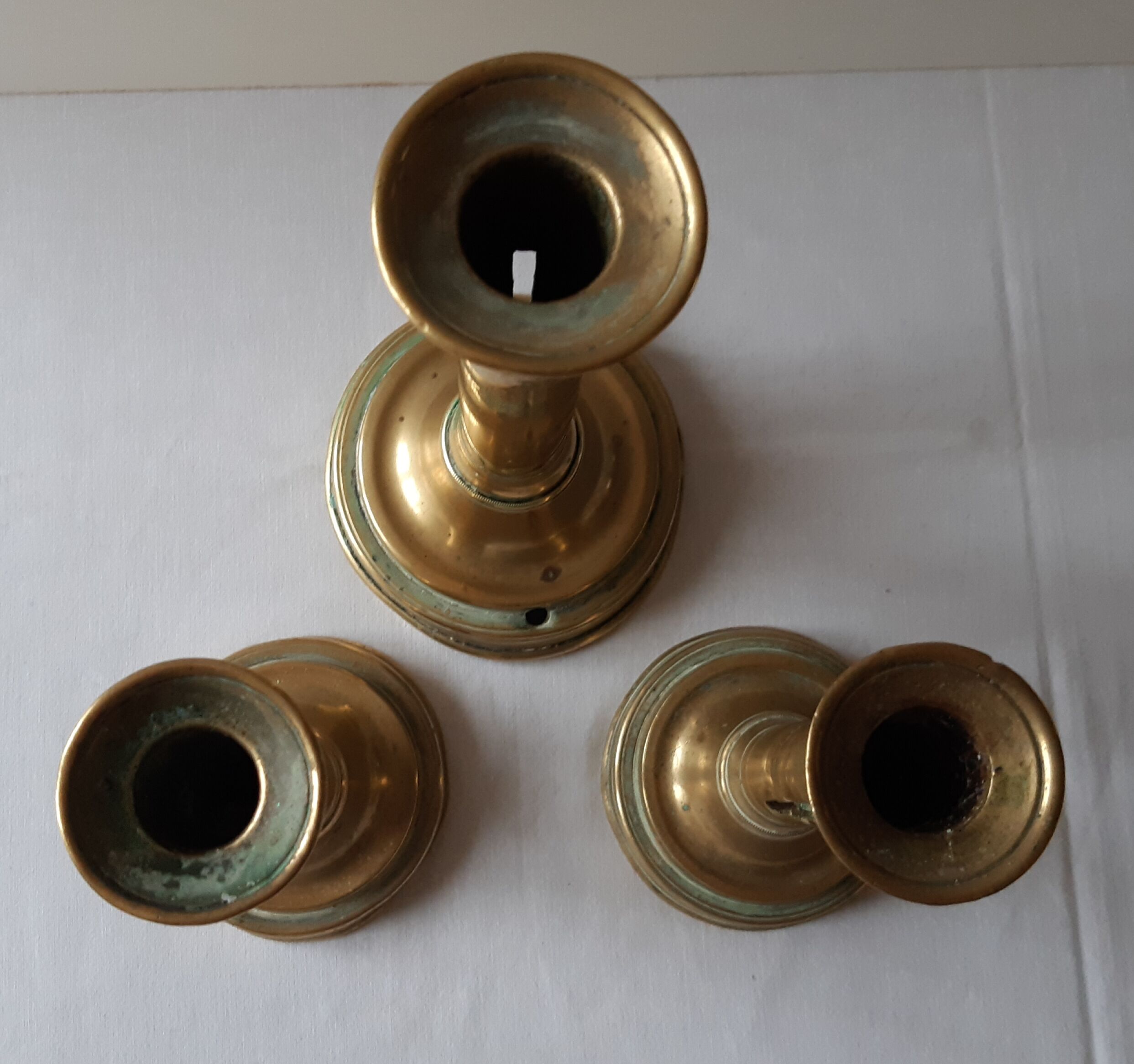 Lot of three old brass candlesticks