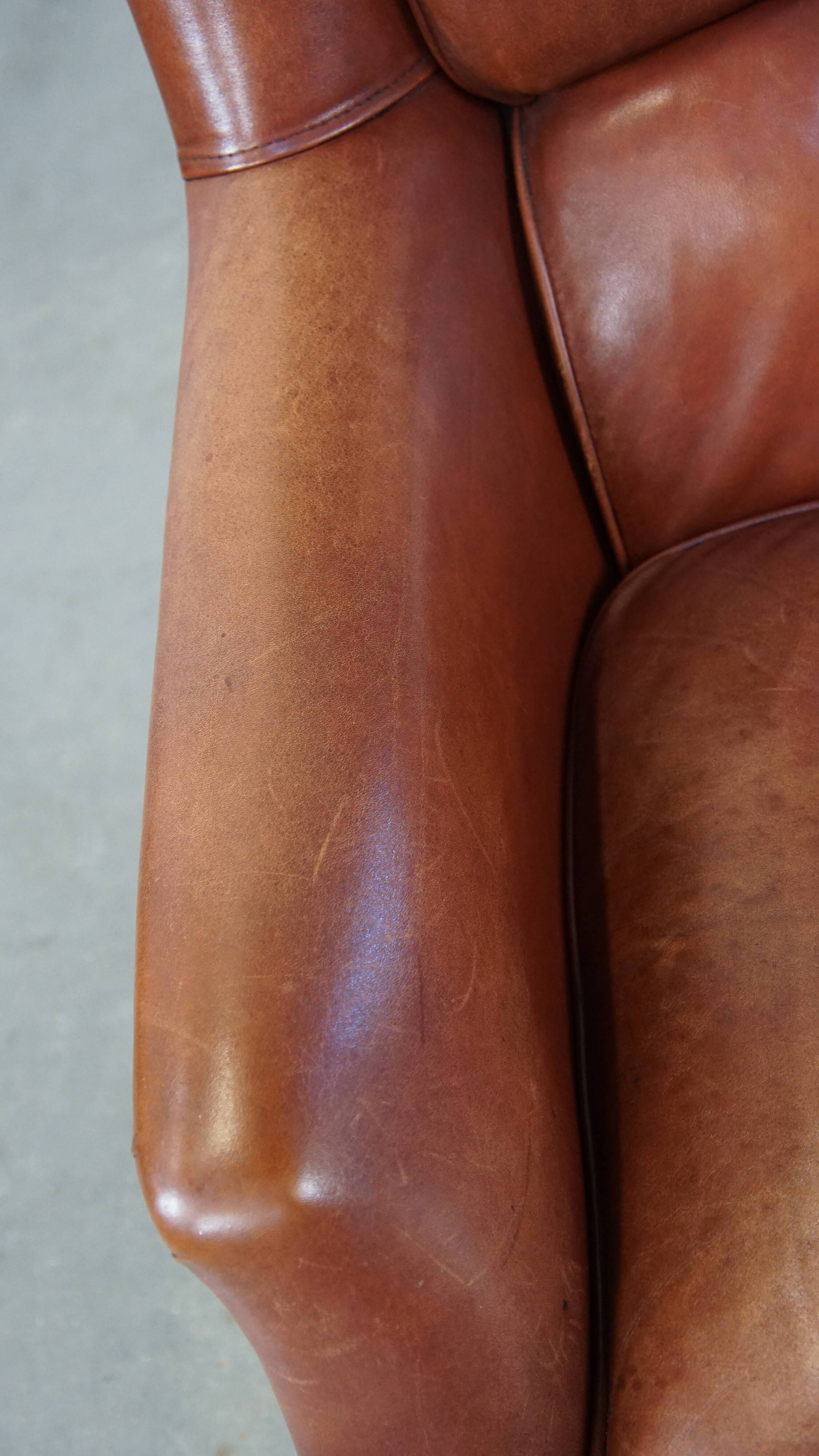 Cowhide armchair in good condition, finished with decorative nails