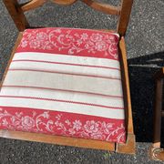 Pair of antique walnut chairs with rose design and red striped cushions.