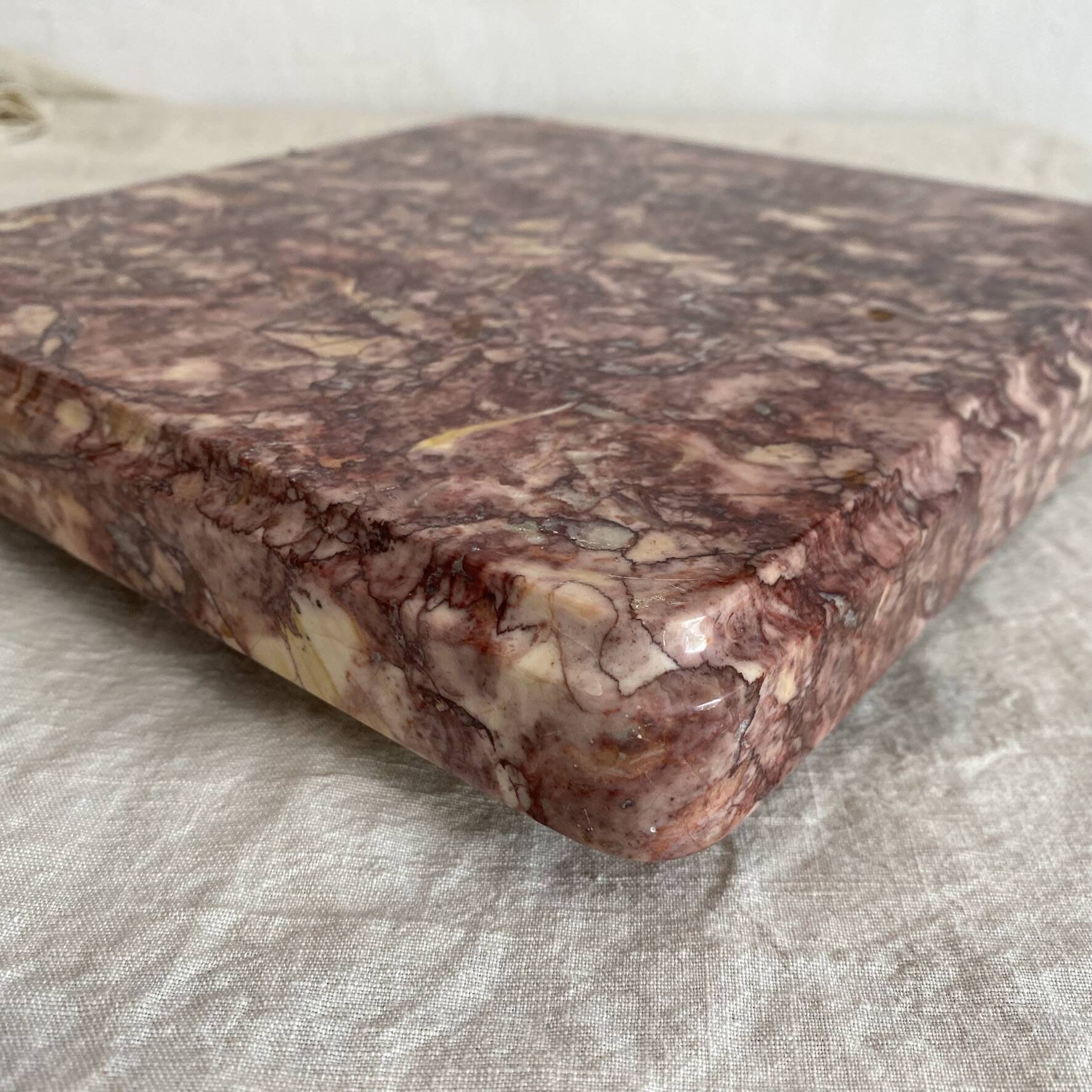 Pink marble trivet with brass ball feet.