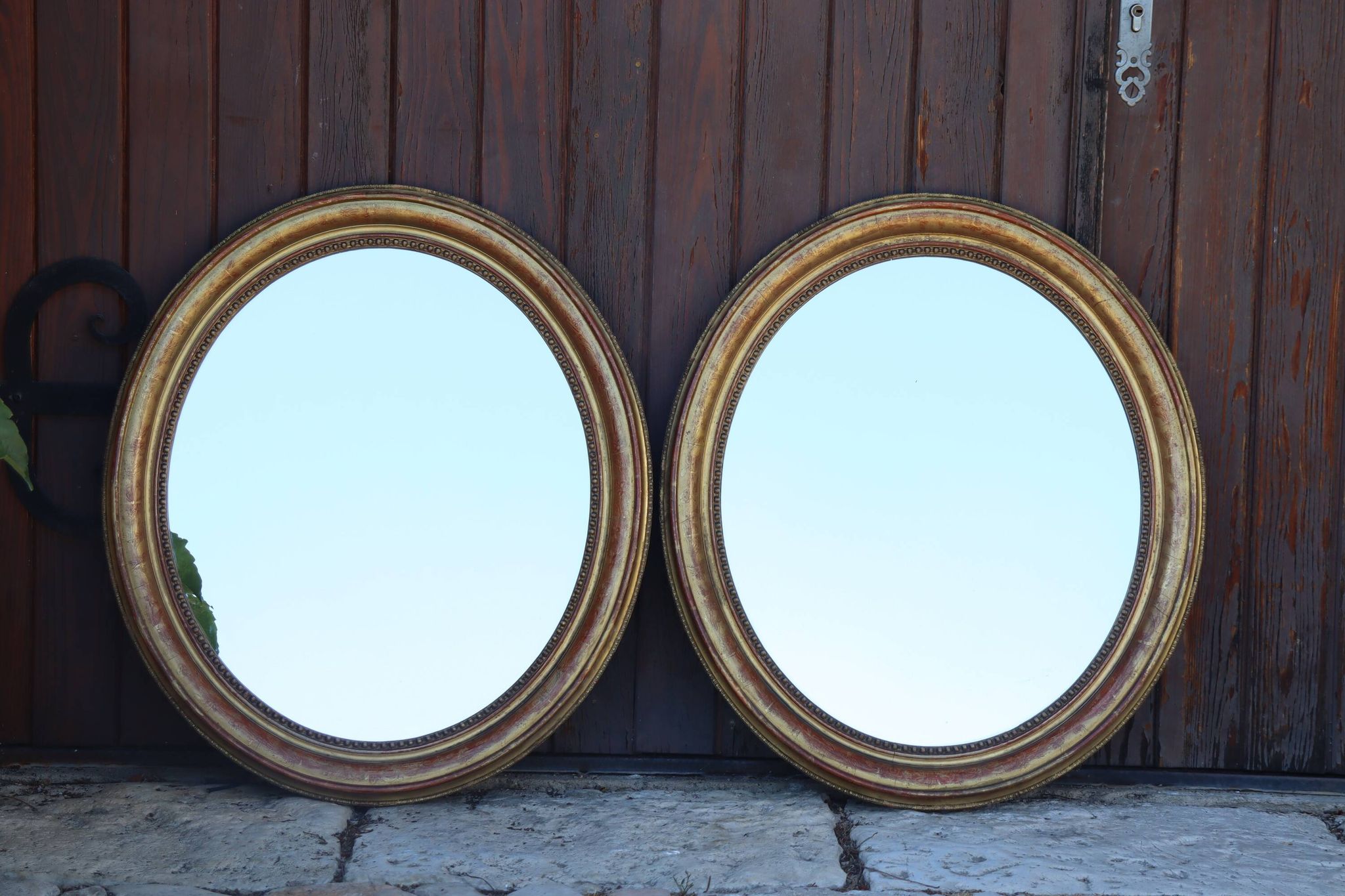 Paire de miroirs ovales en bois doré époque Louis Philippe