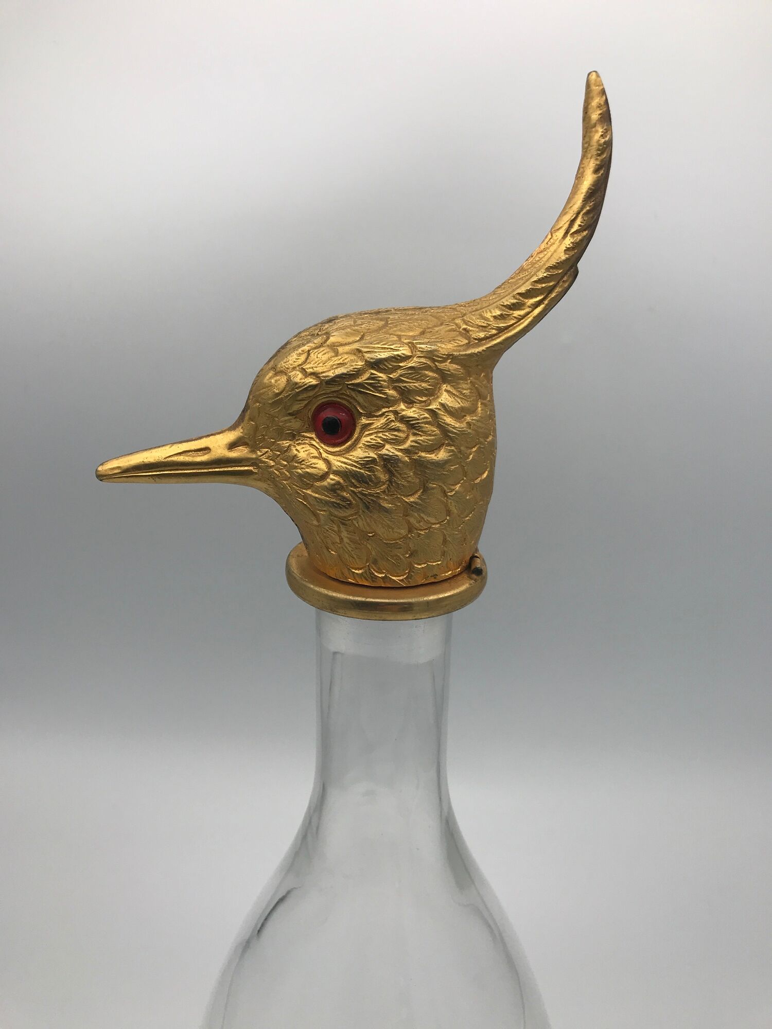 Glass bottle type carafe with gold metal bird head stopper