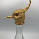 Glass bottle type carafe with gold metal bird head stopper