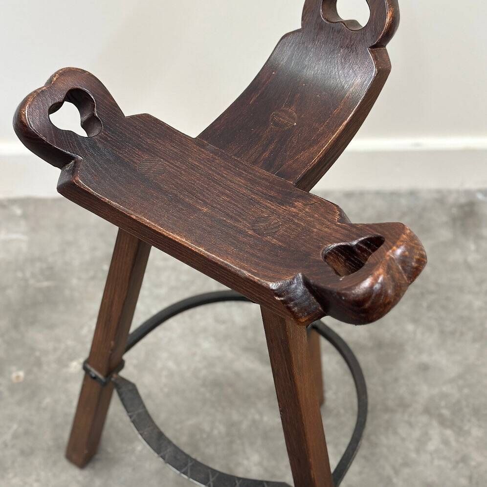 Set of 3 rustic carved oak bar stools with iron footrests, 1970s