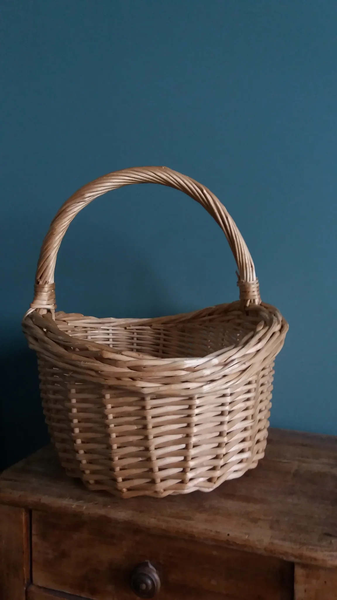 Handcrafted wicker basket with a handle.
