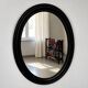 Antique oval mirror in patinated black wood