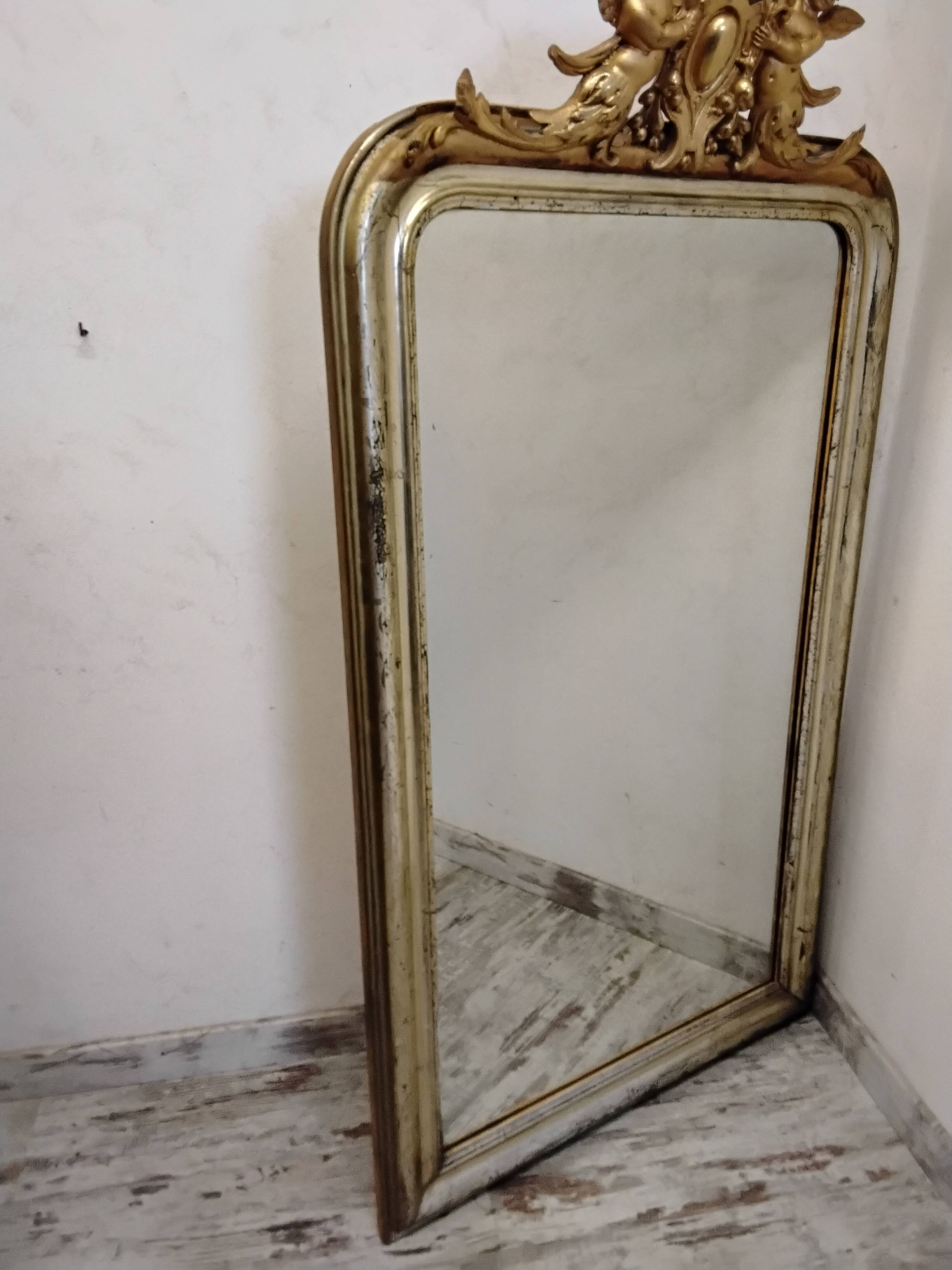Antique mirror with a gilded frame and cherubs.