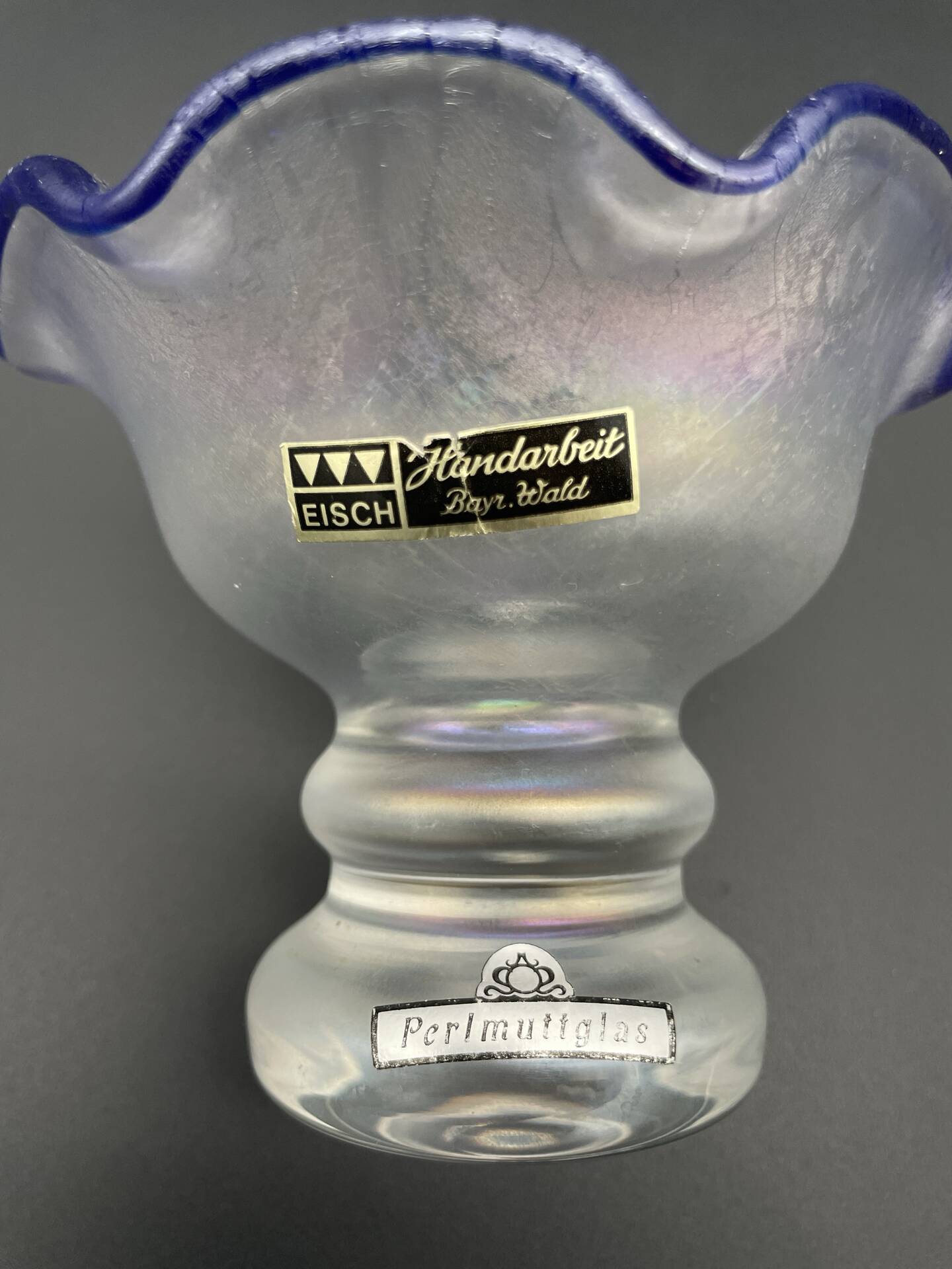 Eisch glass footed cup with pearlescent finish, blue rim.