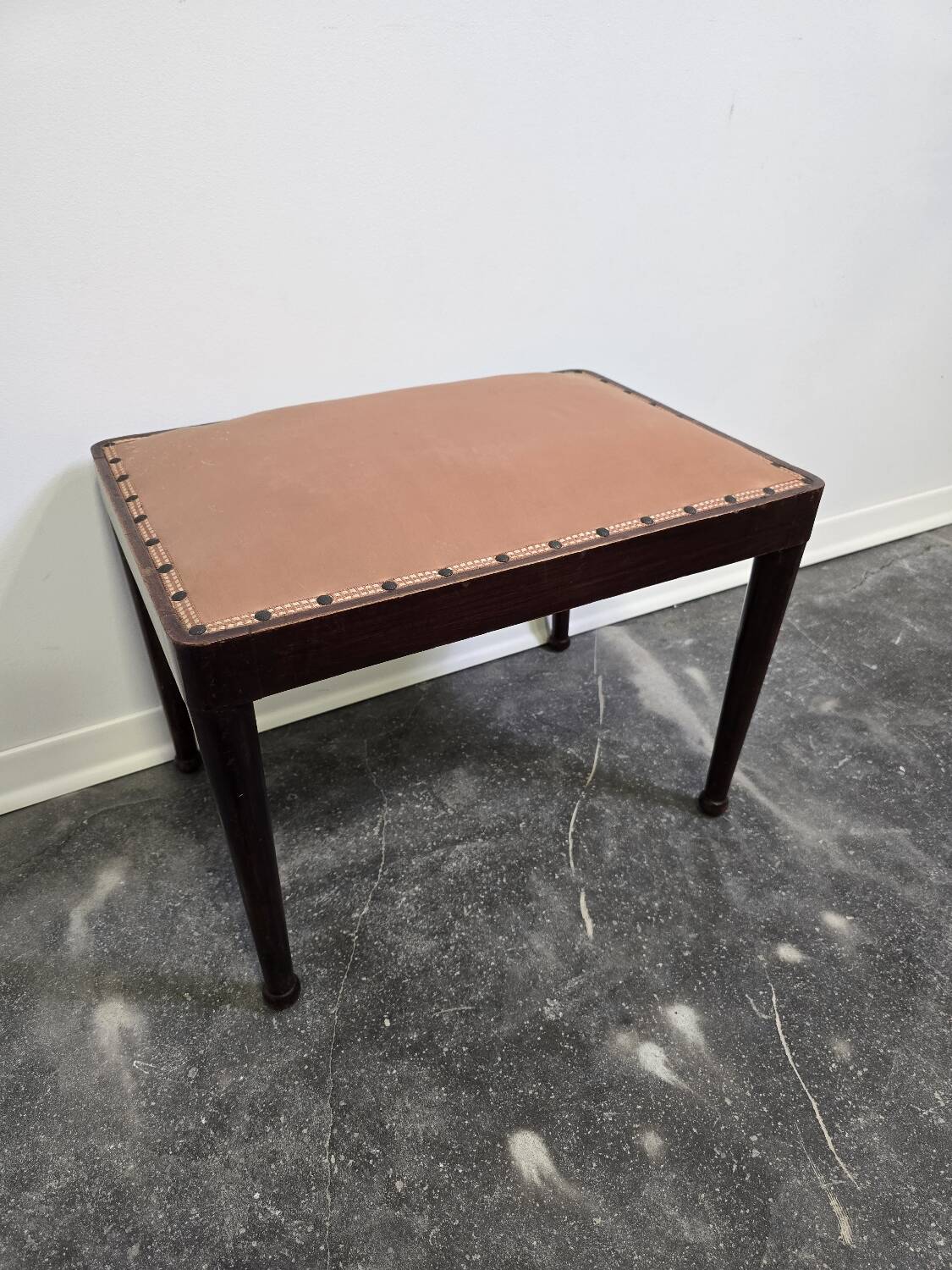 Vintage wooden ottoman from the 1940s with a silk top and studded trim.