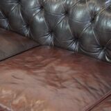 Old dark brown 3-seater cowhide chesterfield sofa with lots of character