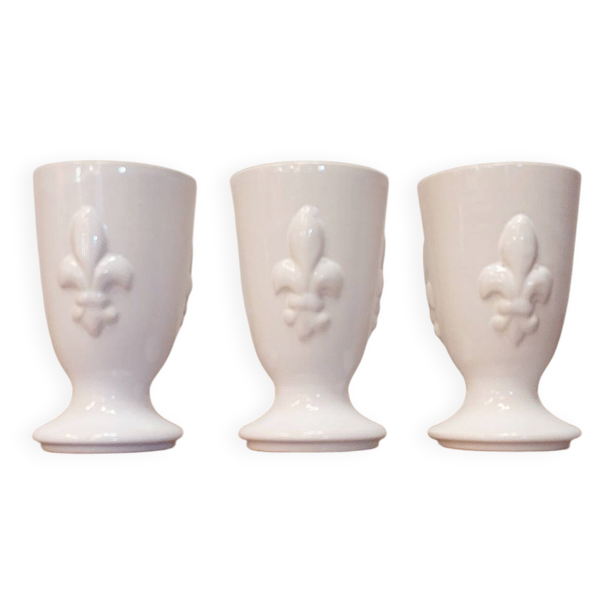 Three antique cups decorated with fleur-de-lis.