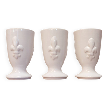 Three antique cups decorated with lilies.