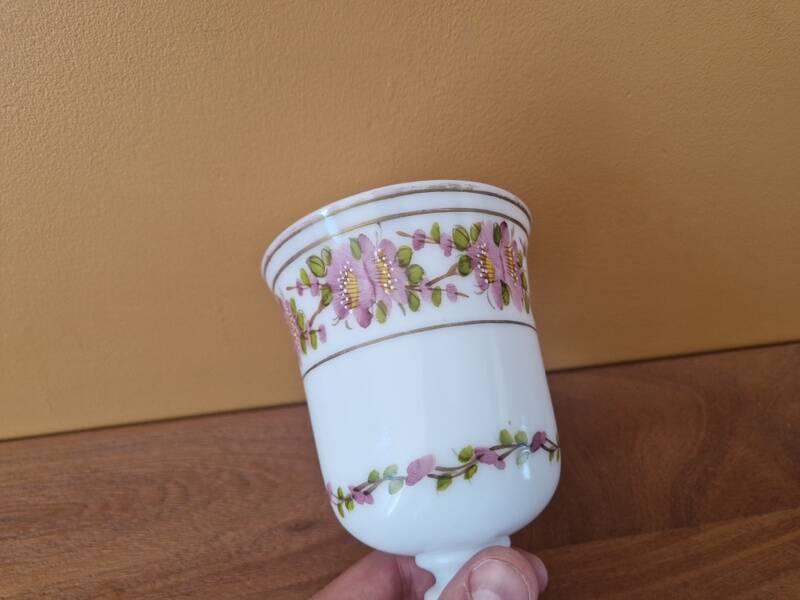 Footed glass in the shape of a chalice in white opaline with a floral decoration.