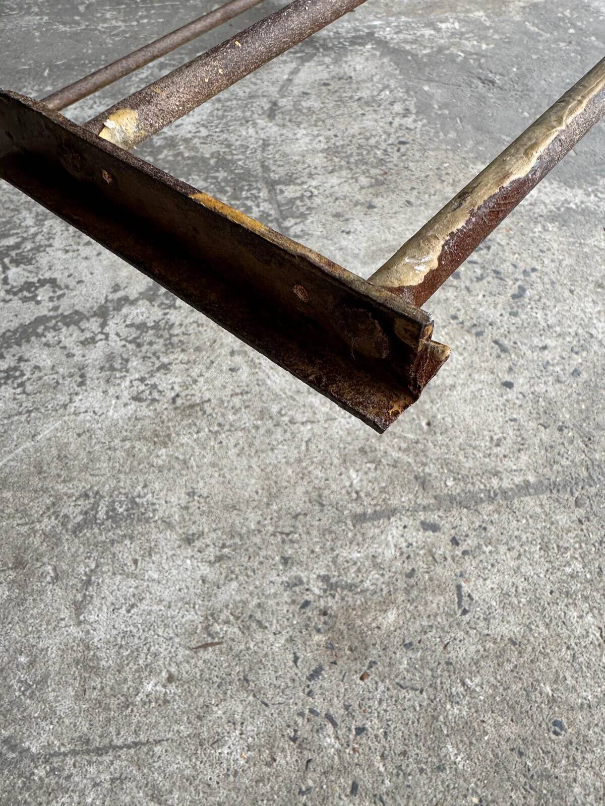 19th-century dark brown wrought-metal rocking chair with cognac leather sling seat, vintage