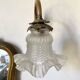 Antique brass wall light with glass shade.