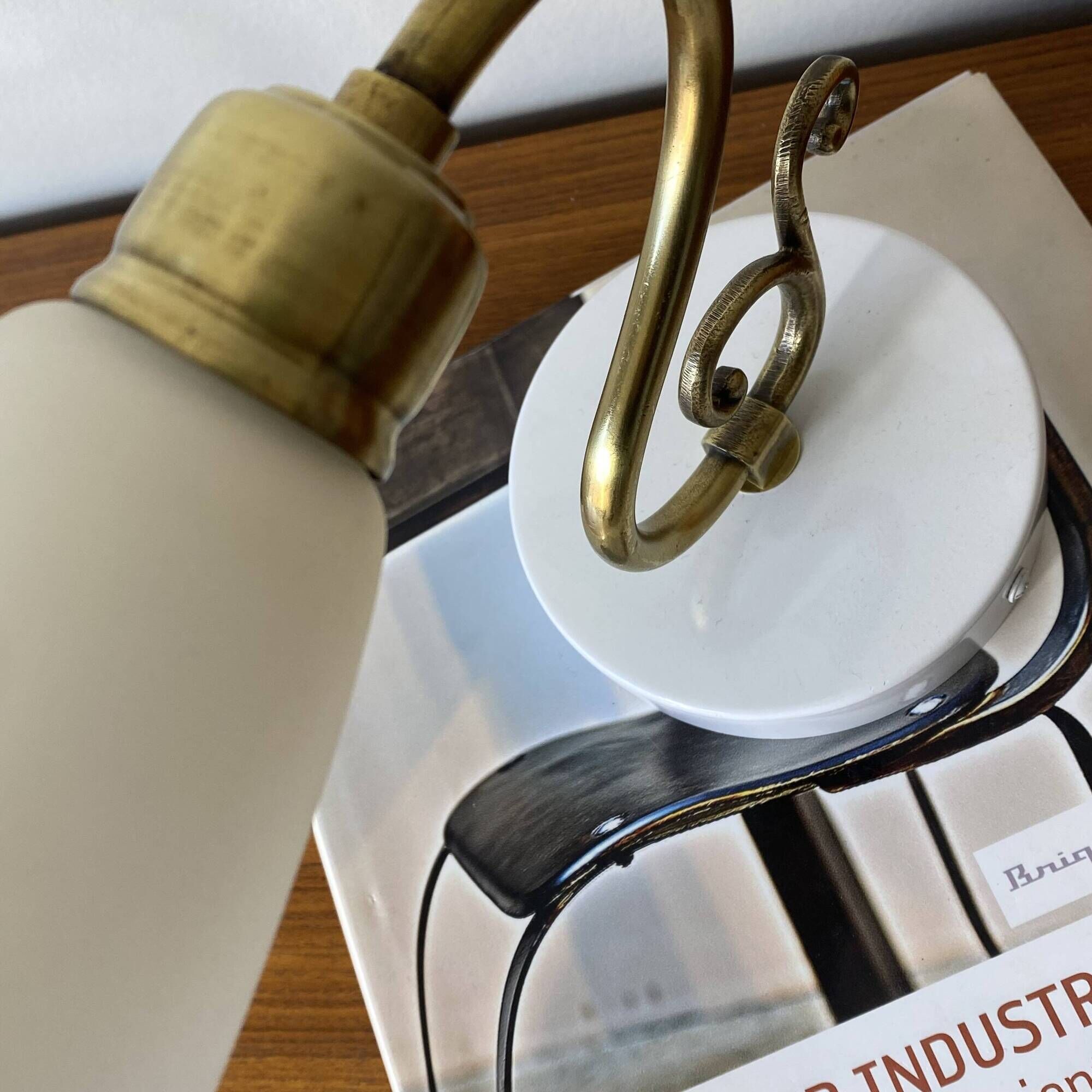 Pair of brass swan neck wall lights with white glass shades.