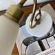 Pair of brass swan neck wall lights with white glass shades.