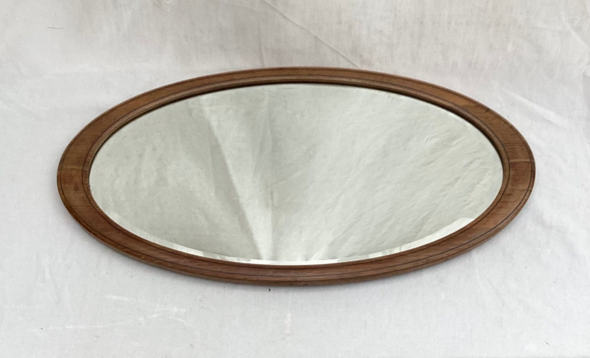 Oval beveled mirror surrounded by light wood dimension: height -74,5cm- width -38,5cm- prof-2cm-