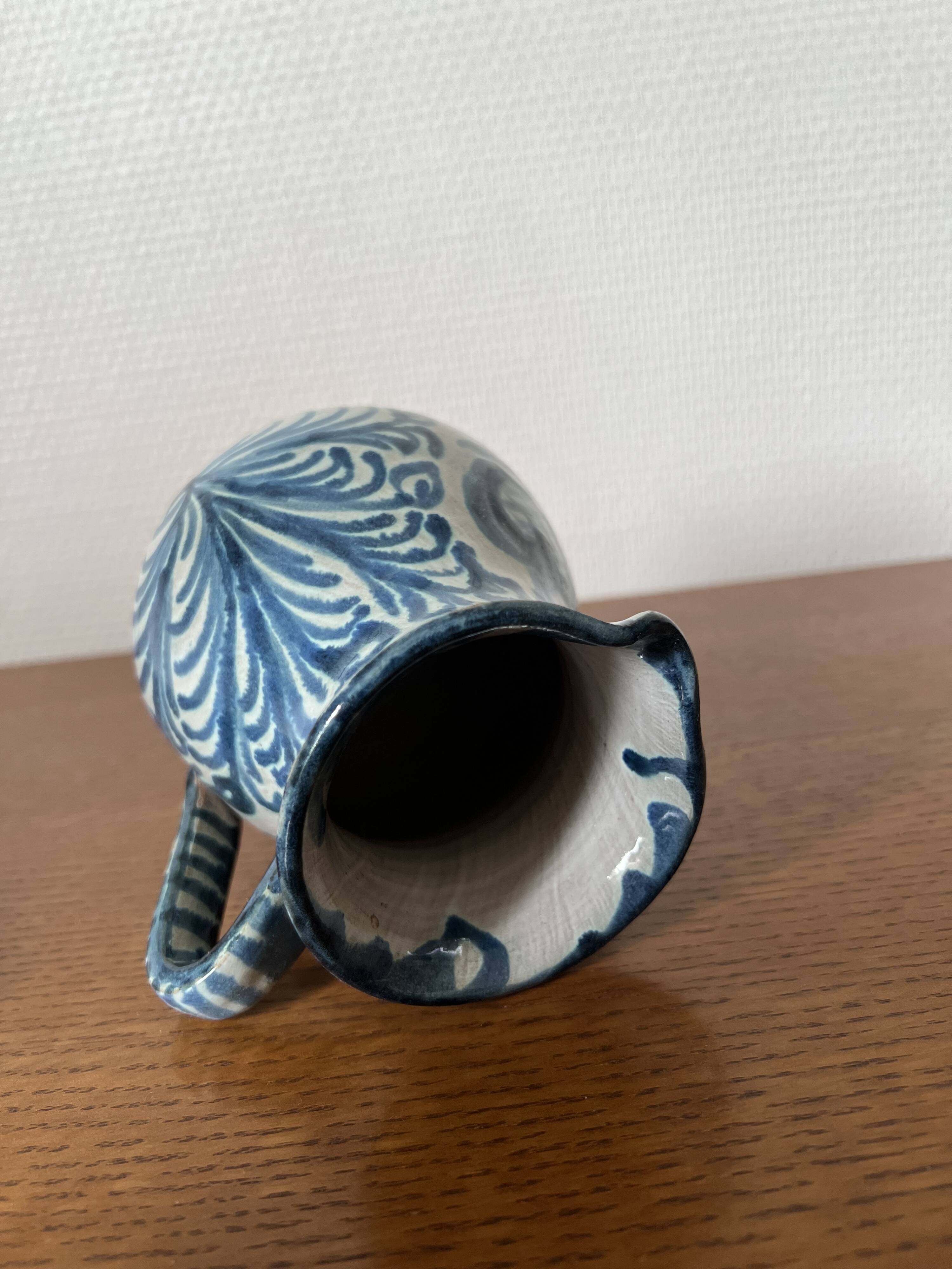Blue ceramic pitcher with floral patterns