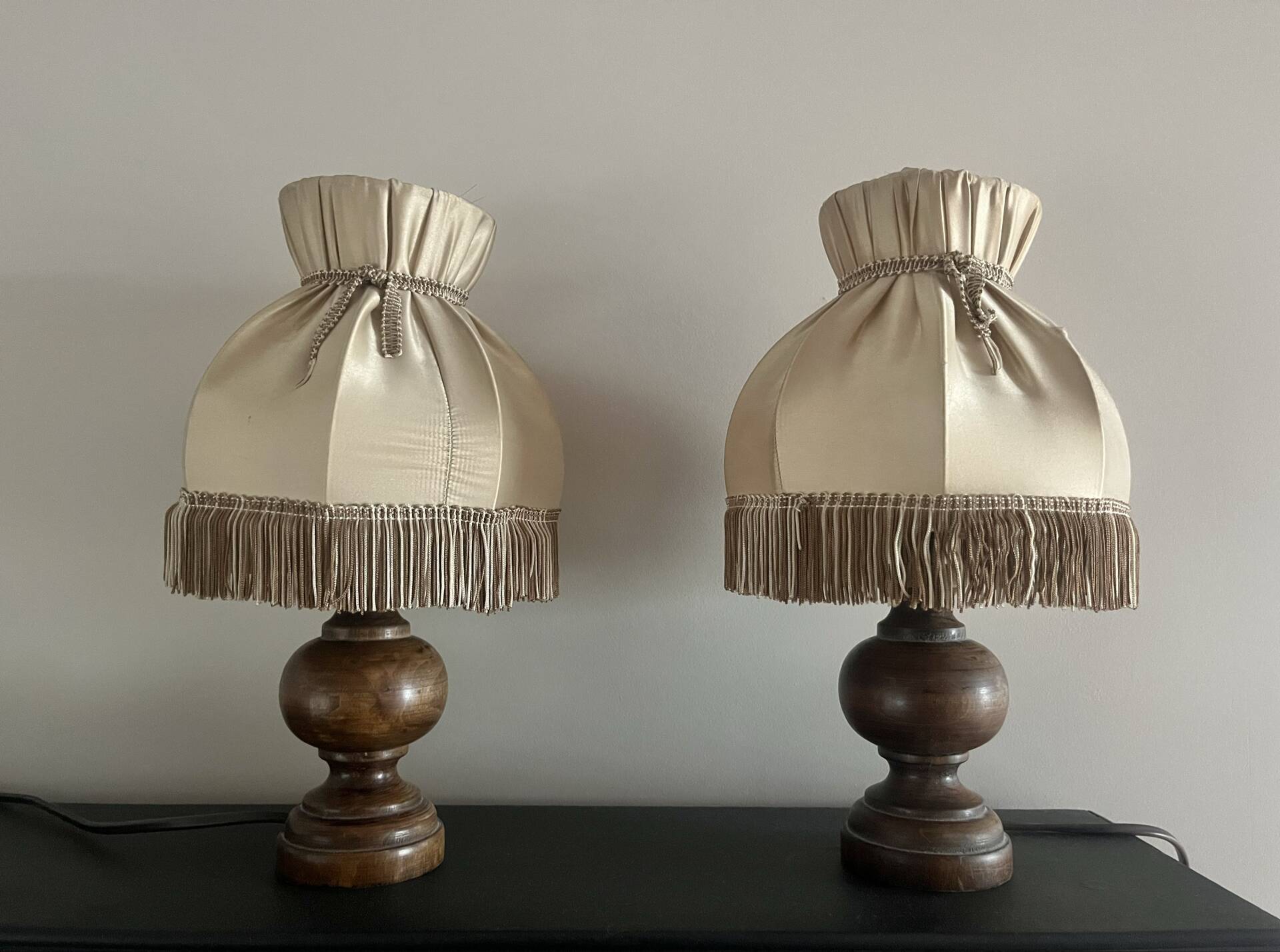 Pair of wooden bedside lamps with vintage fringe lampshades.