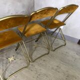 Four folding velvet and brass chairs