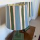 Pair of vintage wooden lamps with their striped beige, blue, and green shades.