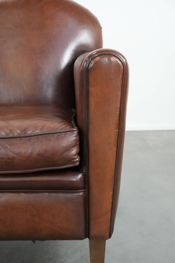 Fauteuil en cuir de peau de mouton au design art déco avec des couleurs chaudes.