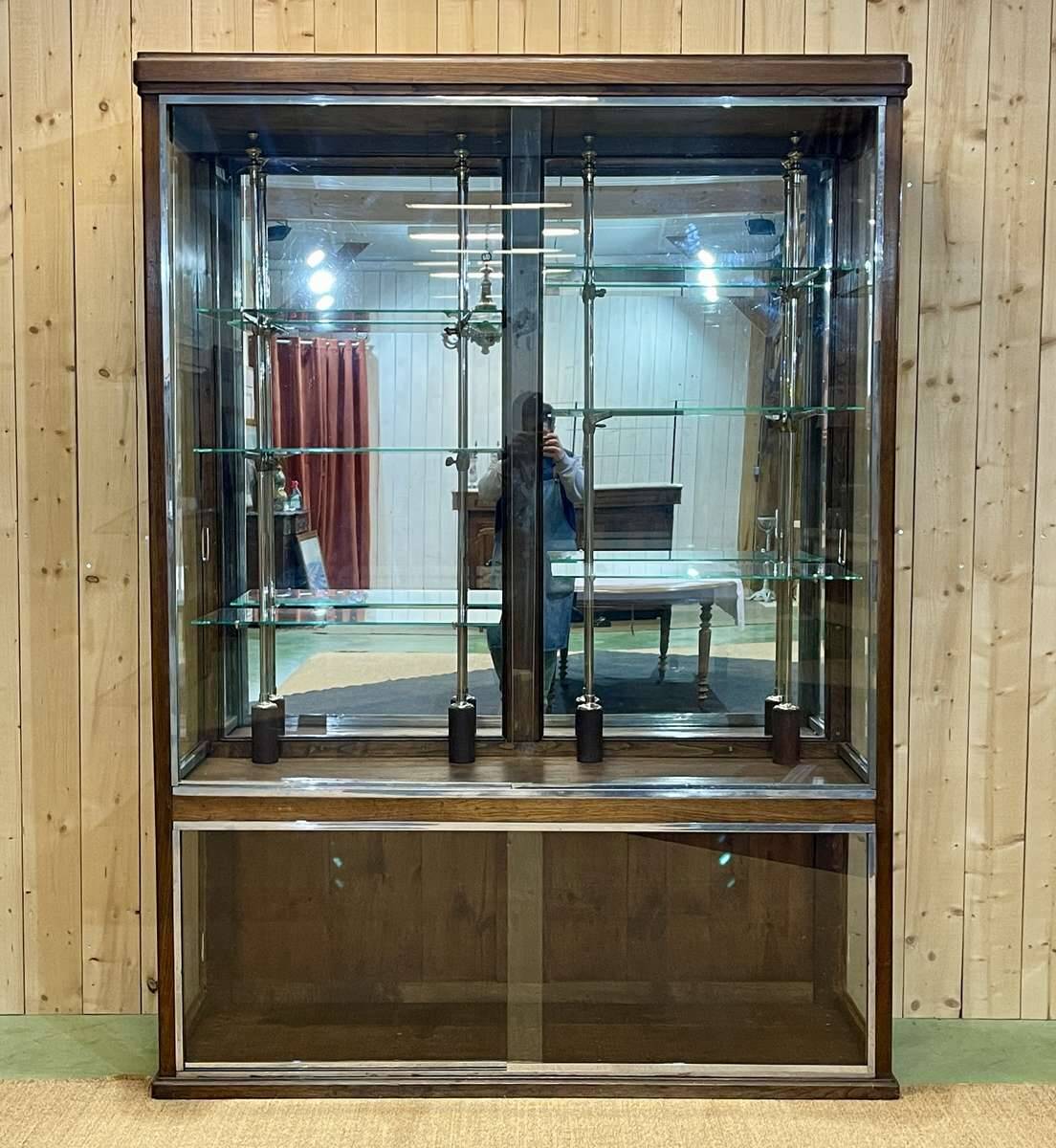 Early 20th-century shop display cabinet in oak with sliding doors.