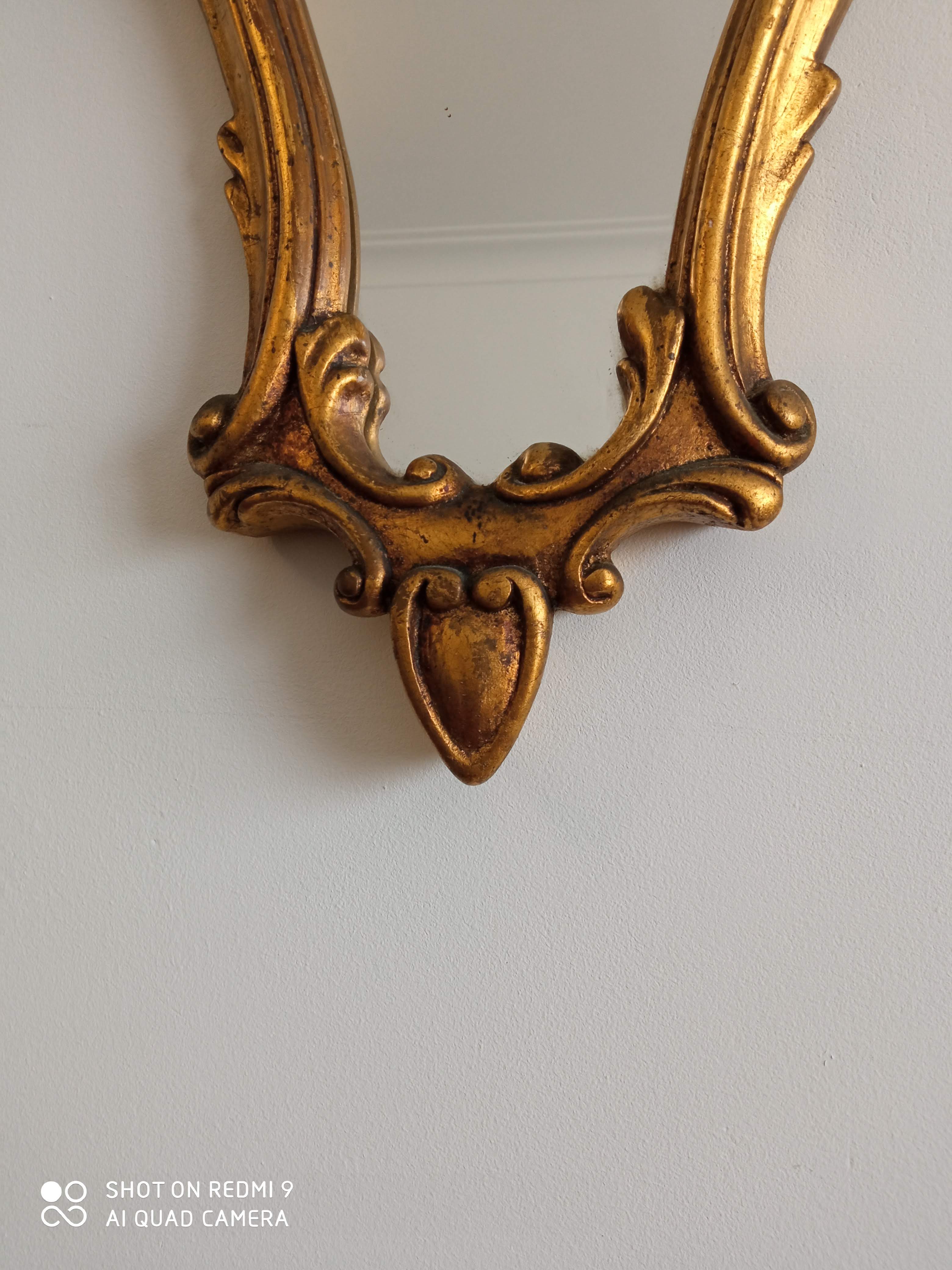 Old wooden mirror and gilded stucco