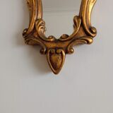 Old wooden mirror and gilded stucco