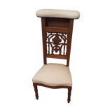 Prie-god furniture in the shape of a low seat with an armnedle on which one kneels to pray