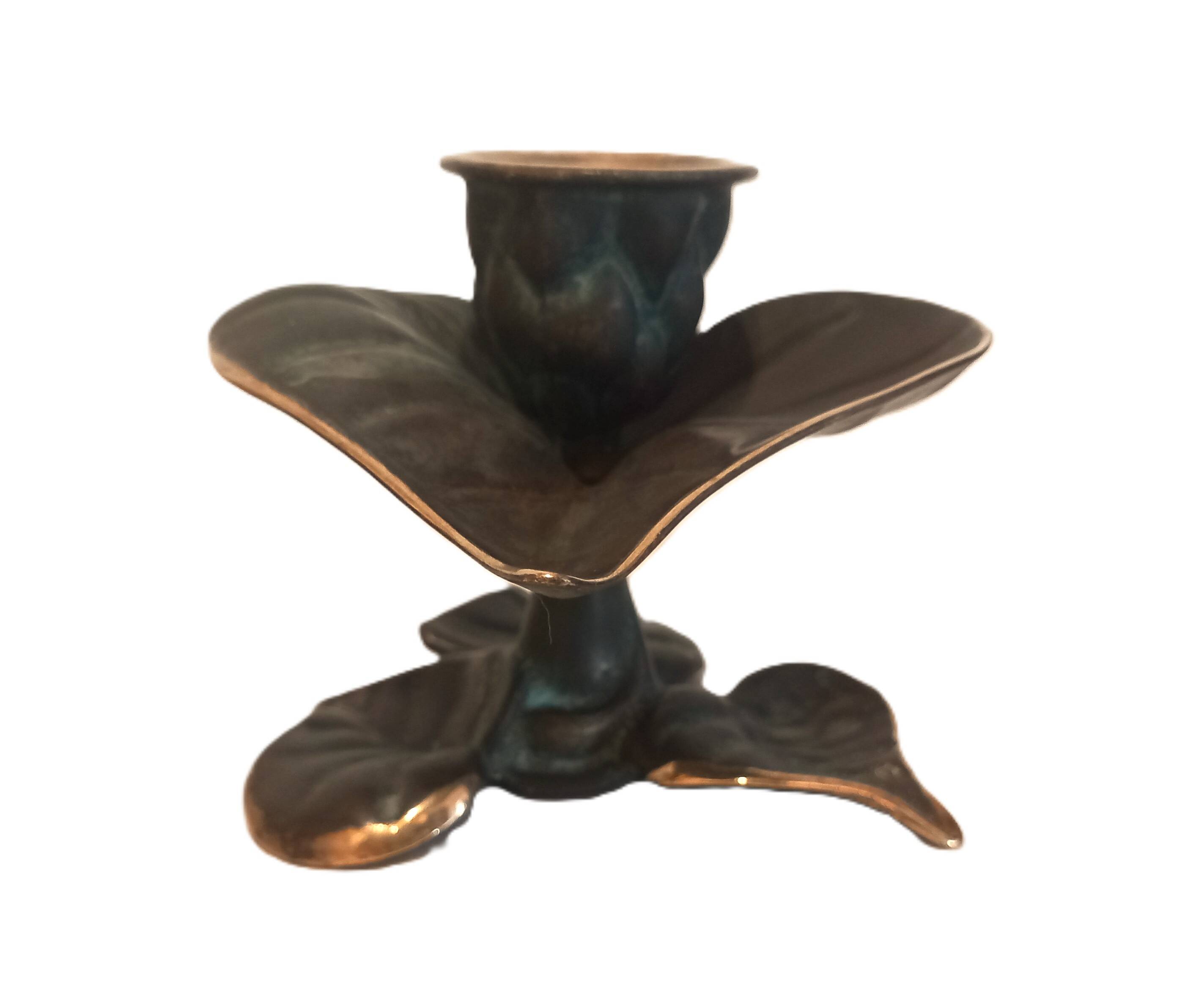 Patinated green brass candlestick with foliage decoration.