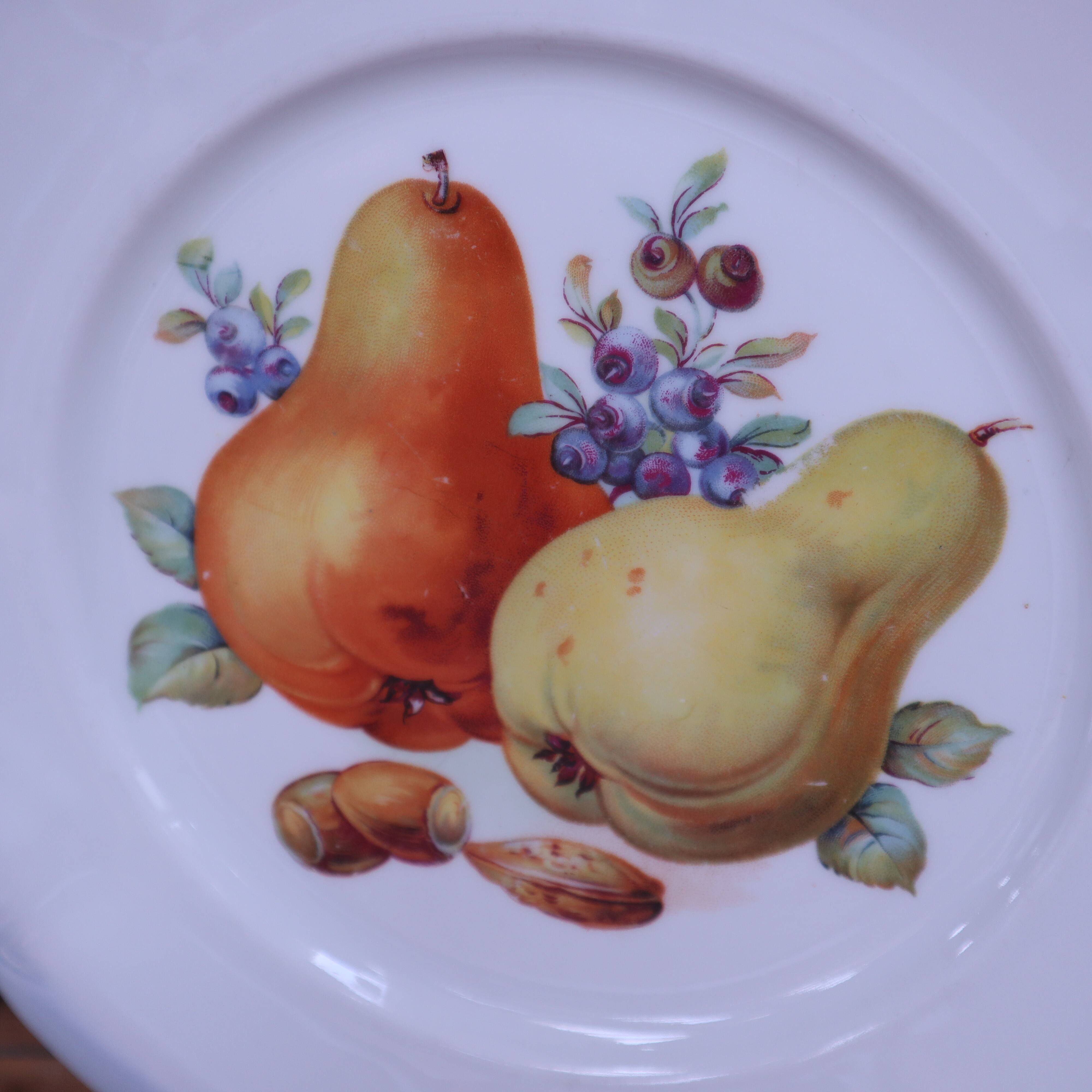 Set of 7 dessert plates and a cake stand with fruit patterns.